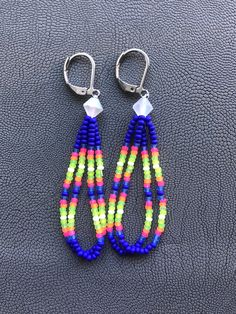 Handmade earrings. Native American beaded earrings made with size 11 seed beads Colors are super bright matte neons pink, orange, green, yellow, white and blue made with a clear matte AB bicone bead topper They measure about 2 inches long with a stainless steel leverback hooks. I now offer free shipping on orders $35.00 and over! Handmade Neon Jewelry For The Beach, Beaded Tutorials, Beads Colors, Native American Beaded Earrings, Native Beadwork, Jewelry Making Project