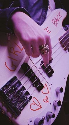 a person playing an electric bass guitar with their fingers on the fretboard,