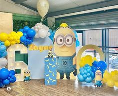 a birthday party with balloons and decorations for a minion themed bash at the park