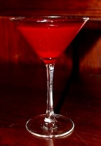 a red drink sitting on top of a wooden table