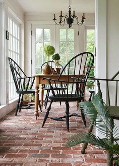 an instagramted photo of a dining room table with chairs and potted plants