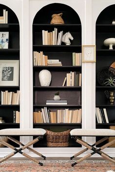 two chairs sitting in front of a book shelf filled with books