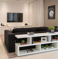 a living room filled with furniture and a flat screen tv mounted to the side of a wall