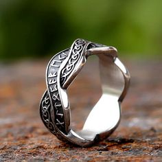 a silver ring sitting on top of a rock