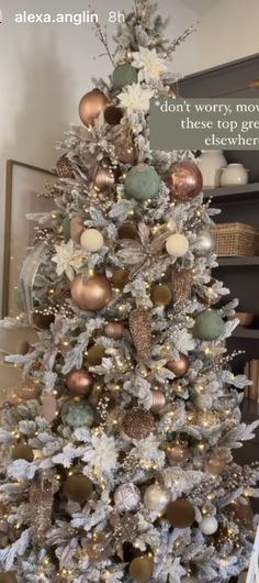 a white christmas tree with gold and silver ornaments