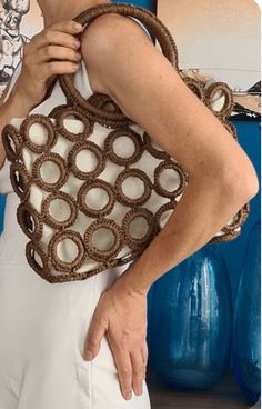 a woman is holding a brown bag with circles on it