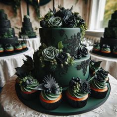 a three tiered green wedding cake with cupcakes