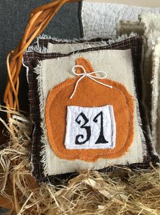 an orange and white pumpkin with the number 31 on it's front is sitting in some hay