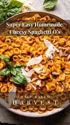 a bowl full of homemade cheesey spaghetti with basil leaves on top and the title super easy homemade cheesy spaghetti o's