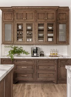 a kitchen with wooden cabinets and white marble counter tops, along with wood flooring