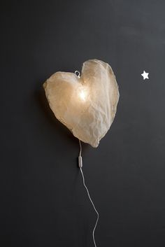 a heart shaped object on a black plate with white stars and a string attached to it