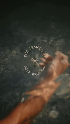 a hand reaching out to the water in front of a compass that reads the temple of sea worship