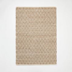 a brown and white rug on a white wall with an odd pattern in the middle