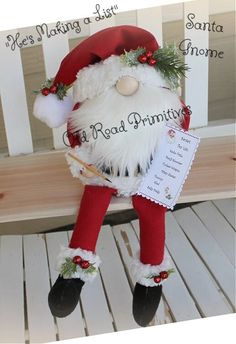 a stuffed santa clause is sitting on a bench with a note in his hand and writing