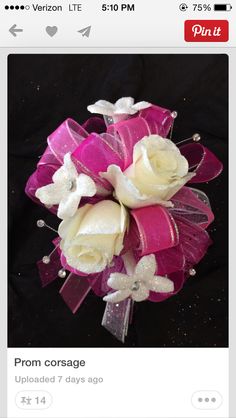 a pink and white corsage with flowers on it