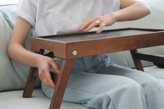 a person sitting on a couch with a wooden chair