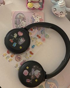 two black headphones sitting on top of a table next to stickers and magnets