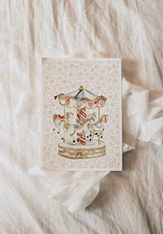 a card with a carousel on it sitting on top of a sheet of white paper