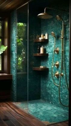 a green tiled bathroom with wooden floors and shelves on the wall, along with a walk in shower