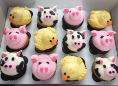 twelve cupcakes with pink and yellow frosting decorated as pigs, piggies, and other animals