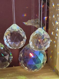 three crystal balls hanging from strings in front of a window