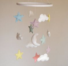 a crib mobile with stars and clouds hanging from it