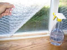 someone is holding a spray bottle near a window with the words bubble wrap insulation on it