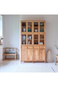 a wooden cabinet sitting next to a white rug