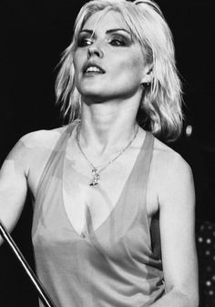 a black and white photo of a woman holding a microphone