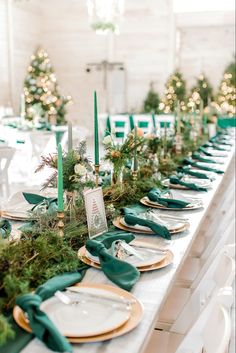 the table is set with plates and place settings, green napkins on each plate