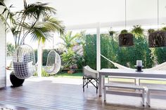 an outdoor patio with hammock chairs and table