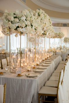 a long table with white flowers and candles