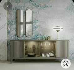 a sideboard with two mirrors on the wall next to a lamp and a mirror