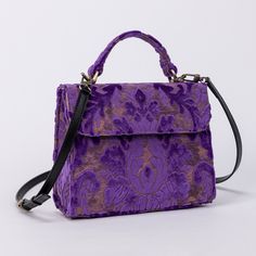 With a nod to the Victorian era, MCW's freshly combines the classic and elegant design of the traditional carpet satchel with a textural and tactile twist. This exquisite top handle satchel is a perfect blend of style and practicality. Spacious interior with zipper and slip pockets, detachable shoulder strap. Sturdy exterior in carpet or velvet, cotton lining. Convenient magnetic flap closure, brass feet for stability. Features: * Detachable, adjustable shoulder strap * Magnetic flap for easy access * Interior slip and zipper pockets * Hand-polished brass hardware * Includes dust bag Dimensions: * Satchel size: 9.50"W x 4"D x 8"H * Adjustable shoulder strap: 43.50" to 51.15" Interior Pockets: * Zipper pocket: 7"W x 5"H * Slip pocket: 8"W x 5.50"H Weight: 1lb 5oz Luxury Rectangular Flap Bag With Adjustable Handle, Luxury Rectangular Satchel With Adjustable Handle, Classic Purple Rectangular Bag, Classic Purple Rectangular Satchel, Classic Purple Bag With Top Carry Handle, Luxury Purple Satchel With Top Carry Handle, Classic Purple Top Handle Shoulder Bag, Classic Purple Shoulder Bag With Detachable Handle, Vintage Formal Shoulder Bag With Adjustable Handle