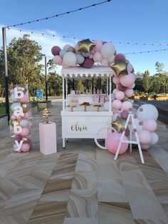 an ice cream cart decorated with pink, white and gold balloons