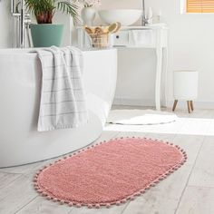 a bathroom with a pink rug on the floor