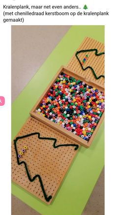 a wooden peg board with beads in the shape of a christmas tree and a green background