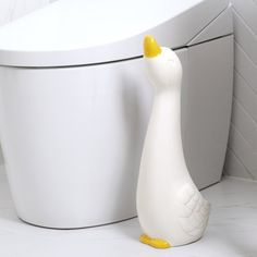 a white toilet sitting next to a white bath tub with a yellow duck on it