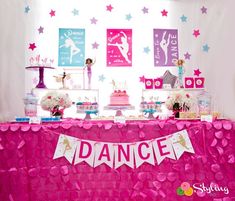 a pink table topped with cake and desserts