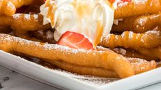 a white plate topped with waffles covered in whipped cream and strawberries