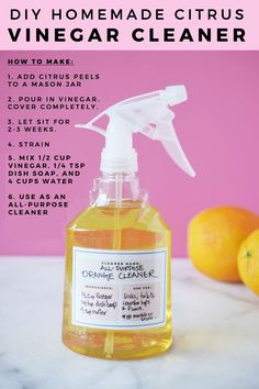 a bottle of homemade citrus vinegar cleaner next to some oranges