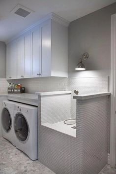 a washer and dryer in a white laundry room with gray tile flooring