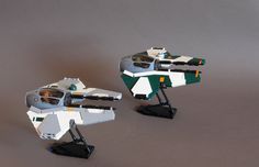 two lego star wars vehicles sitting on top of each other in front of a gray background