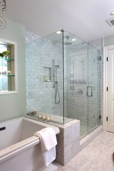 a bathroom with a walk in shower next to a bathtub