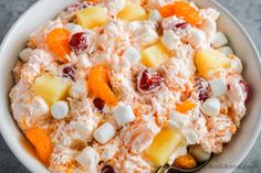 a bowl filled with fruit salad on top of a table