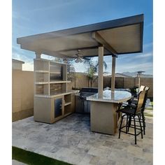 an outdoor kitchen and grill area with chairs