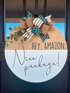 a wooden sign that says hey amazon nice package on the front door with a bow