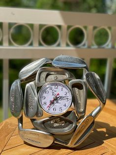 a metal clock sitting on top of a wooden table