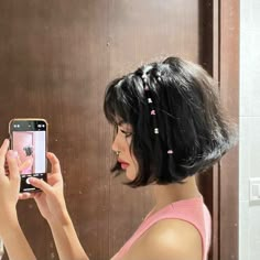 a woman taking a selfie in front of a mirror with her cell phone up to her ear