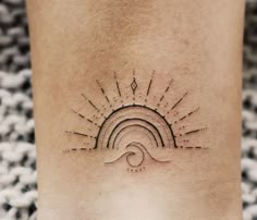 a woman's foot with a sun and wave tattoo on the side of her leg